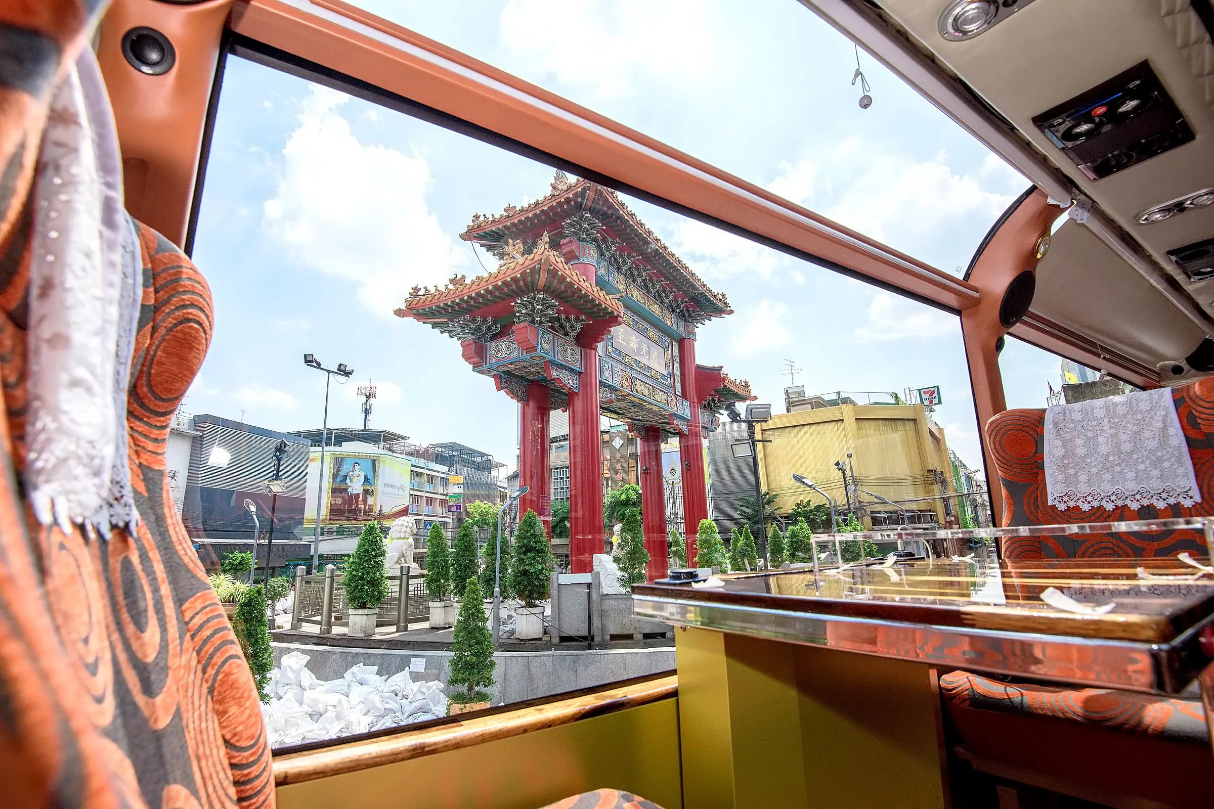 Guests dining in cool air-conditioned comfort while sunny Bangkok streets pass the panoramic window
